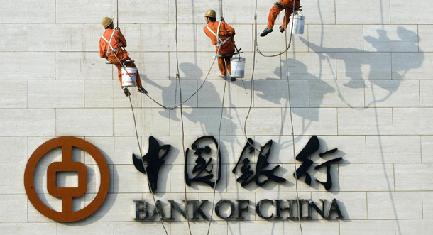 Chinese workers scale the wall near the logo for the Bank of China Ltd., China's second biggest commercial bank in Beijing, China. (AP/Ng Han Guan)