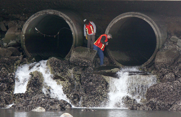 Workers conduct tests on a pair of 96 in. storm drain pipes flowing into Puget Sound near Tacoma, Washington. A new Frontline documentary, "Poisoned Waters" examines the causes of pollution and health of Puget Sound and the Chesapeake Bay. (AP/Ted S. Warren)