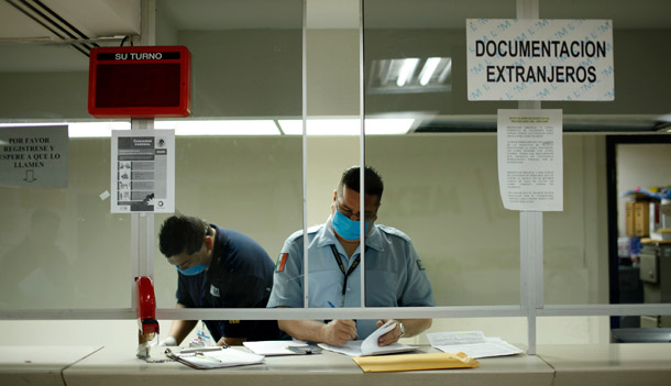 Mexican immigration officials wear masks at the border crossing in Tijuana. President Obama has called swine flu a concern, but "not a cause for alarm," while conservative pundits have wrongly blamed infections in the United States on immigrants. (AP/Guillermo Arias)