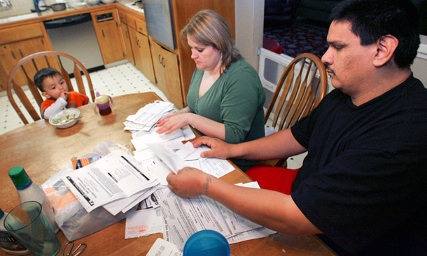 Tanya Duarte and her husband, Fernando, look over bills while their son Jordan looks on in Fresno, Calif. Due to the recession, the Duartes, like many families throughout the country, are close to losing their homes to foreclosure. (AP Photo/Gary Kazanjian)