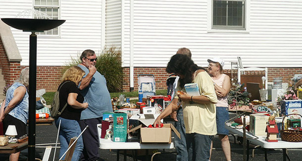 People browse items at a yard sale. This time of year yard sales are in full swing, and they're a great place to pick up reusable items. (Flickr/<a href=