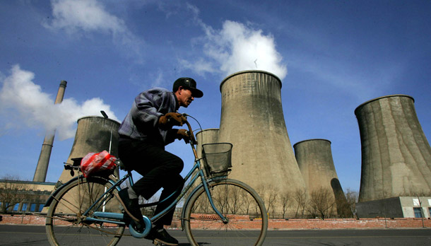 A man cycles past cooling towers of the coal-powered Fuxin Electricity Plant in Fuxin, in China's northeast Liaoning province. Heading into the Copenhagen climate talks later this year we need a better accounting of what the United States—and other countries such as China—are doing to achieve meaningful carbon reductions. (AP/Greg Baker)