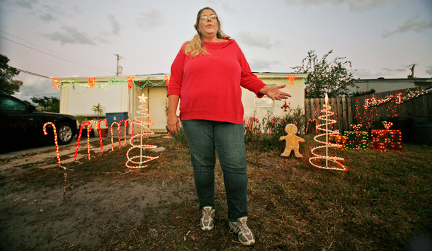 Cynthia Casey stands outside her home late last year talking about the costs of medical treatment for her husband. Even though the couple is using a COBRA insurance plan she obtained after she was laid off three months ago. Due to the high costs of medical treatment, she said the couple could lose their home while she searches for a job. (AP/J. Pat Carter)