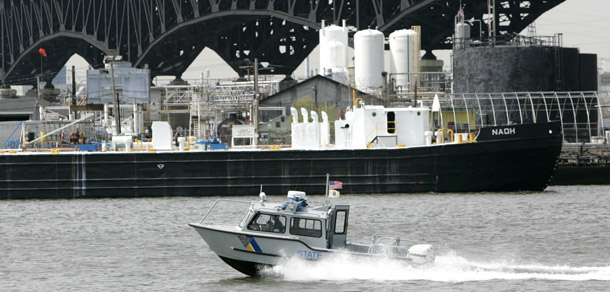 A New Jersey state police boat cruises past Kuehne Chemical Co. Inc., on the Hackensack River under the Pulaski Skyway in Kearny, NJ. Today the House Homeland Security Committee is holding a hearing on legislation designed to protect Americans from a terrorist attack on a high-hazard chemical facility. (AP/Mike Derer)