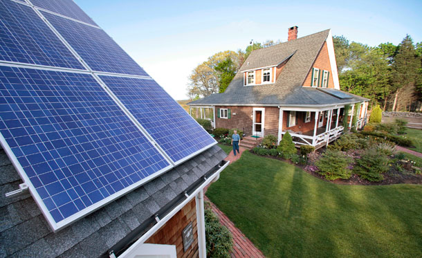 Len Bicknell walks from his house on May 8, 2009, to his garage where his solar energy panels are mounted on the roof in Marshfield, MA. The Green Bank would help finance diverse set of technologies with appropriate safeguards to protect taxpayers. (AP/Stephan Savoia)