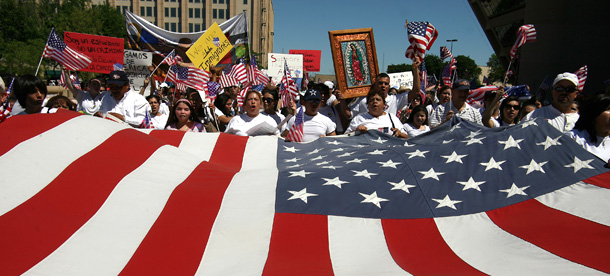Demonstrators march with an American flag during an immigration reform rally in Dallas, Texas. (AP/Rex C. Curry)