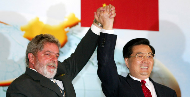 Chinese President Hu Jintao, right, and Brazilian President Luiz Inacio Lula da Silva raise their arms at a seminar on investments and trade in 2004. China’s presence in Latin America and the Caribbean will continue to grow, so the sooner the Obama administration can find ways to cooperate with China in the region the better. (AP/Adriano Machado)