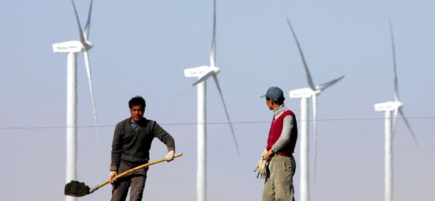 Workers build a highway near a wind farm in China's northwest Gansu province. (AP/Greg Baker)