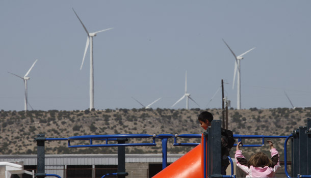 Children play on the playground at Sterling Elementary School in Sterling City, TX as wind mills spin in the background on April 2, 2009. (AP/LM Otero)