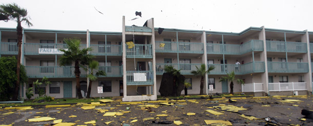 Portions of an apartment complex roof are blown off by high winds as Hurricane Dolly makes landfall July 23, 2008, in South Padre Island, TX. Average hurricane wind speeds could potentially increase by 3 percent to 24 percent by 2100 as the ocean surface warms, leading to higher costs for hurricane damages. (AP/David J. Phillip)