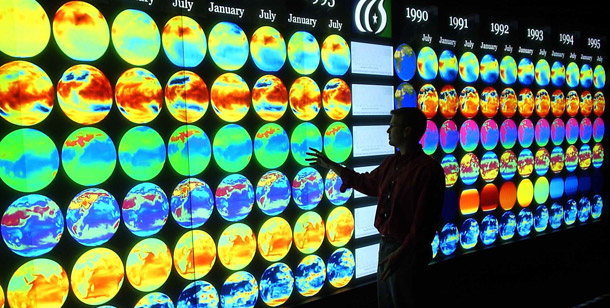 Researcher Jamison Daniel stands before a wall of computer-generated images of global climate change at the Department of Energy's Oak Ridge National Laboratory. (AP/Oak Ridge National Lab)