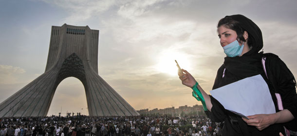 An Iranian woman uses her mobile phone in front of hundreds of thousands of supporters of leading opposition presidential candidate Mir Hossein Mousavi on June 15, 2009. The continuing protests in Iran over that country’s rigged June 12 presidential election will continue to influence Tehran’s foreign policy. (AP/Ben Curtis)