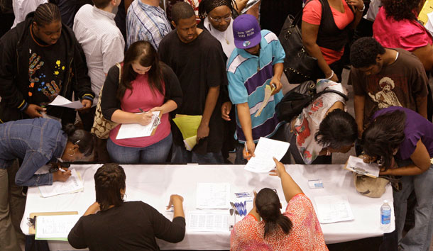 Job seekers fill out job applications at one of the company booths at the Mayor's Youth Jobs and Opportunities Fair on April 23, 2009, at the convention center in Cincinnati. Minority workers, teens, and less-educated workers have unemployment rates far higher than the national average. (AP/Al Behrman)