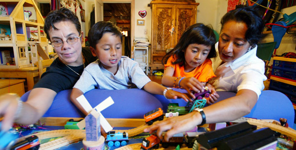 Lyn Shimuzu, left, and her partner, Silvia Castellanos, right, play with a train set with their children, 6-year-old twins Che, left, and Liana, right, at their home in San Francisco. Recent data has found that denying LGBT people equal access to family benefits and other civil rights may be contributing to higher poverty rates in the LGBT community than in the general population overall. (AP/Eric Risberg)