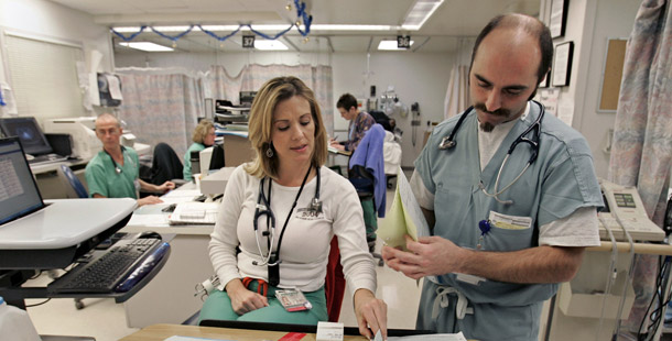 An emergency room nurse and doctor confer at the University of California-Davis Medical Center. In every state individuals and households are paying more for health care, and state uninsured rates continue to rise. (AP/Rich Pedroncelli)