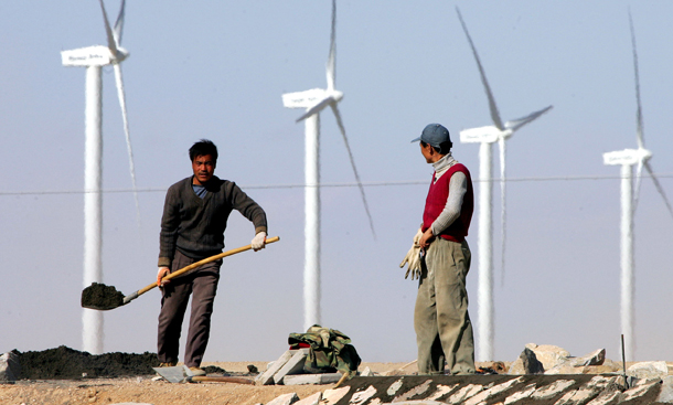 Workers build a highway near a wind farm in the Gobi desert, in China's northwest Gansu province. If we are to achieve a best-case climate scenario, strategic collaboration will be necessary. (AP/Greg Baker)