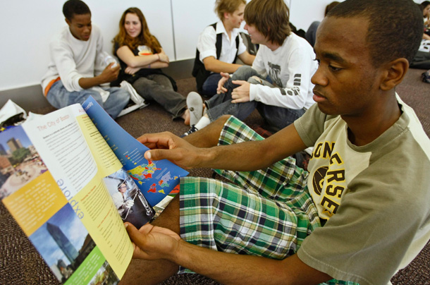 A California high school students looks over brochures at a college fair. (AP/Damian Dovarganes)