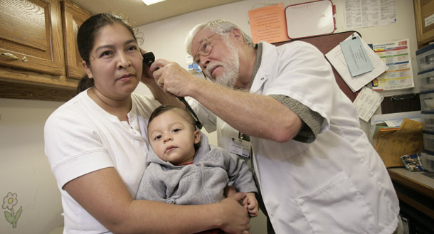 An immigrant woman and her child are treated at a mobile health clinic in Richmond, VA. Of the 46.3 million uninsured people in this country, less than 7 million are undocumented immigrants, and immigrants use fewer health care resources than U.S. citizens. (AP/Catholic Health Association)