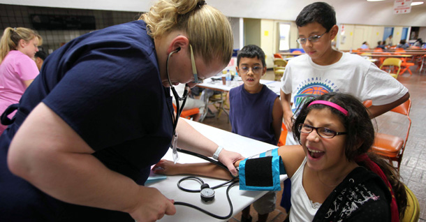 Nurse Allison Tanksley checks Samantha Fierro's blood pressure during a free medical care clinic. (AP/Nick Ut)