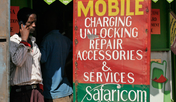 A Kenyan man talk on a mobile phone at a shop selling Safaricom products in the Kibera slum in Nairobi, Kenya. (AP/Khalil Senosi)