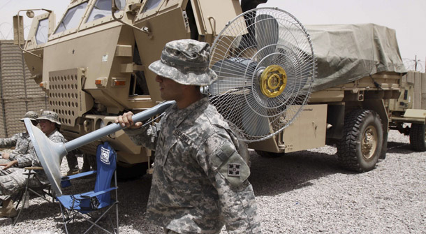 A U.S. soldier carries a fan as U.S. troops prepare to leave their military base after handing it over to the Iraqi forces in Qurna, north of Basra, Iraq on August 1, 2009. (AP/Nabil al-Jurani)