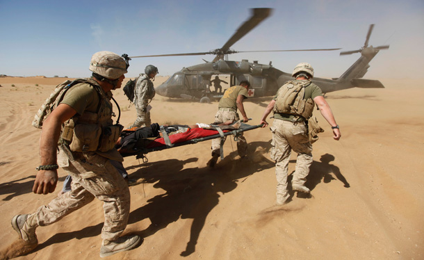 U.S. Marines carry an Afghan civilian gunshot victim to a Blackhawk helicopter for medical treatment. (AP/Brennan Linsley)