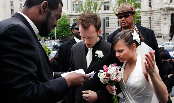 Bishop Harry R. Jackson Jr. prays with Jonathan Paul Ganucheau and Denise Buckbinder Ganucheau of Dallas, Texas, before performing a religious wedding ceremony that was part of a protest against the District of Columbia city council's approval of legislation recognizing same sex marriages performed in other states. (AP/Jacquelyn Martin)