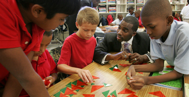 Teacher Hayward Jean, 27, works with his fourth grade students during a math lesson on patterns. (AP/Mary Ann Chastain)