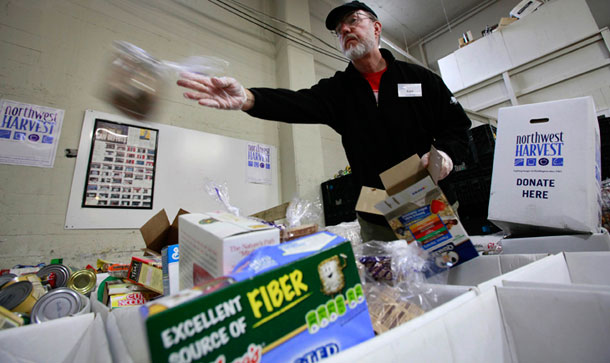 Volunteer Ken Newman sorts donated food at the Cherry Street Food Bank, run by Northwest Harvest, near downtown Seattle, a week before many Americans will sit down to Thanksgiving dinner. (AP/Elaine Thompson)