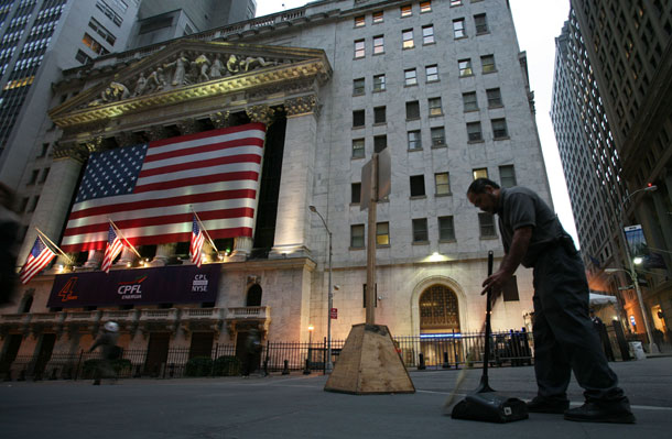 Rolando Gamez sweeps up litter on Wall Street in front of the New York Stock Exchange in New York. The federal government needs money to deal with the budget deficits, and  Wall Street would be a well-heeled source of those funds. (AP /Mark Lennihan)