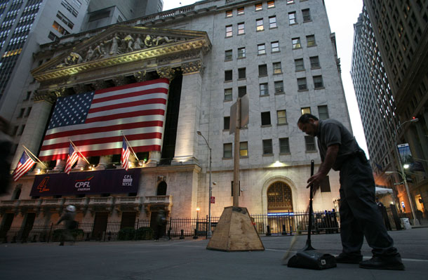 Rolando Gamez sweeps up litter on Wall Street in front of the New York Stock Exchange in New York. The federal government needs money to deal with the budget deficits, and Wall Street would be a well-heeled source of those funds. (AP /Mark Lennihan)