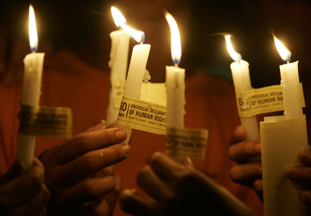 Activists hold lighted candles to mark the 60th anniversary of the U.N. Declaration of Human Rights in Manila, Philippines, on December 10, 2008. This year marks the occasion on which to ask whether all the human rights declarations, treaties, covenants and conventions that have been ratified since 1948 have truly made any difference in the struggle for a more humane and rights-respecting world. (AP/Bullit Marquez)