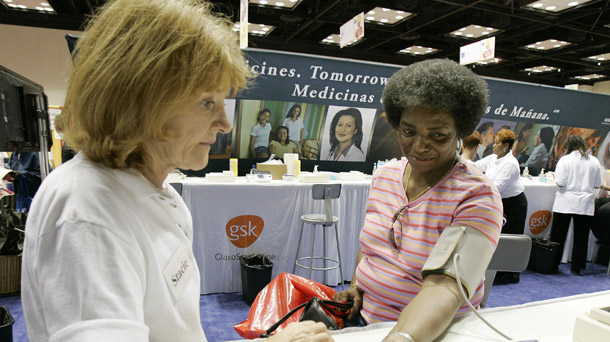 Theresa Johnson of Indianapolis, right, has her blood pressure taken by Stacie Siekierski during the Black and Minority Health Fair at Indiana Black Expo's Summer Celebration in Indianapolis. (AP/Darron Cummings)