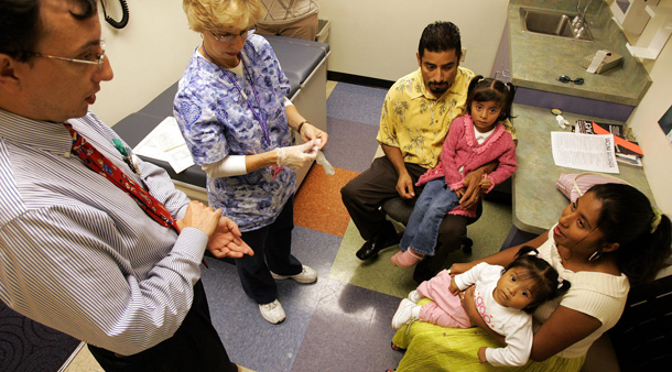 Dr. Diego Chaves-Gnecco talks with the Solis family during a visit on to a bilingual clinic that he runs through Children's Hospital of Pittsburgh. (AP/Gene J. Puskar)