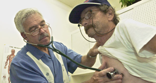 Physician's assistant  Tom Sievert, left, listens to the heart of James William Franklin, 62, at a clinic in Sacramento, CA. Thirty percent of adults age 50 to 64 spent at least 10 percent of their disposable income on health care in 2005, compared to 16 percent of their younger counterparts. (AP/Al Goldis)