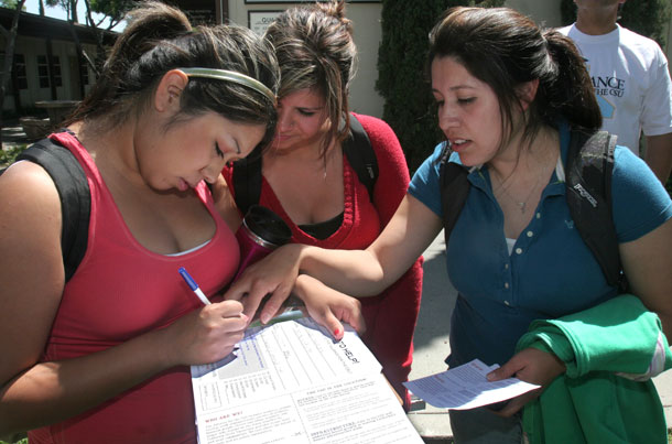 Students at Butte Community College in California help each other fill out paperwork. (AP/Rich Pedroncelli)