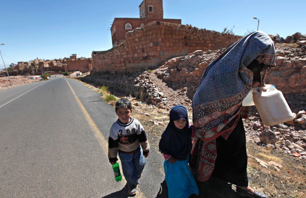 An elderly Yemeni and two children walk on the main road leading to the village  of Kawkaban, north of the capital San'a, Yemen on January 10, 2010. Investing much needed U.S. assistance in good governance, anti-corruption efforts and economic reform alongside military assistance is our best chance at enhancing the long-term stability of Yemen and preventing radicalization. (AP/Nasser Nasser)