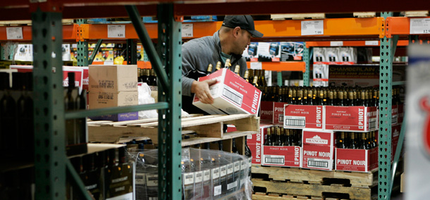 A man stocks shelves with wine at the Costco Wholesale Corporation store in Tacoma, Washington. (AP/Ted S. Warren)