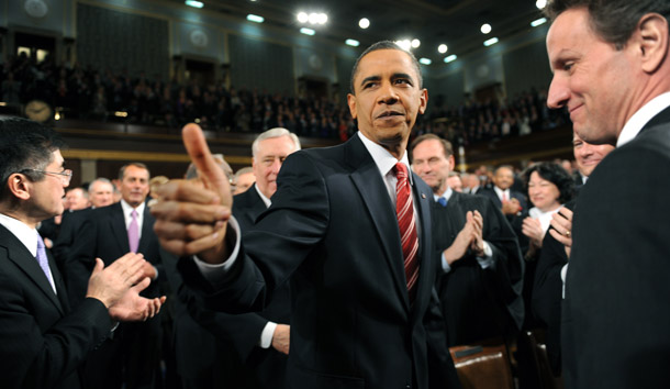 President Barack Obama walks down the center aisle greeting members of Congress on his way to deliver his State of the Union address. At right is Treasury Secretary Tim Geithner. (AP/Tim Sloan)