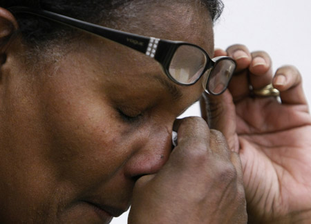 Yves Louis Lys, a native Haitian, wipes the tear from her eye as she talks about the Haitian earthquake before a Haitian relief meeting on January 13, 2010 in Evanston, IL. Granting Haitian nationals already in the United States a Temporary Status Designation would help Haiti's recovery. (AP/Charles Rex Arbogast)