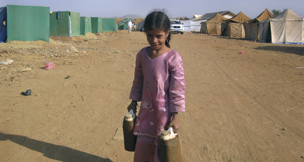 A Yemeni girl carries water supplies at the Marzaq Refugee Camp in Northern Yemen on December 11, 2009. Yemen faces a water crisis and conflicts in the North and the South. (AP/Mohammed al-Qadhi)