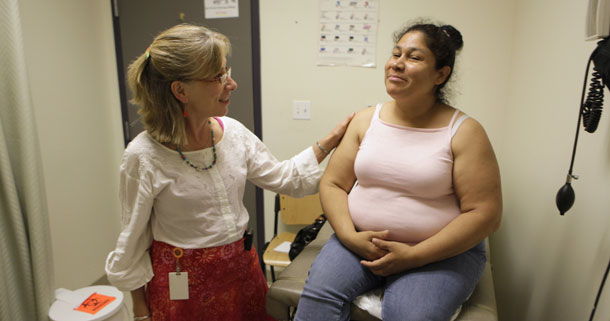 Delmira Maravilla, right, smiles as she talks to Dr. Barbara Benzwi at La Clinica in Oakland, CA, on July 15, 2009. Half of Hispanics and more than a quarter of African Americans do not have a regular doctor, compared with only one-fifth of white Americans. (AP/Marcio Jose Sanchez)