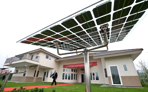 A U.S. delegate walk past solar panels on display outside a Future House, a clean-energy resident development project in Beijing, China, on July 16, 2009. As China aims to lead the world's clean-energy race, reports from the Milken Institute and the Heritage Foundation have become a distraction on the real debate on clean energy economy. (AP/Andy Wong)