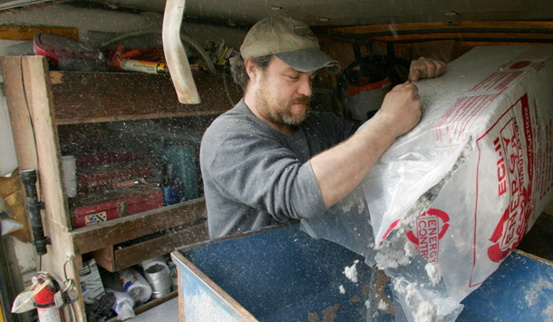 Rich Schorr, an employee of Arick and Sons Insulation Co. in Columbus, OH, loads insulation into a hopper so it can be blown into the attic at a residence in Powell, OH. HOME STAR would provide rebates to consumers for the purchase and proper installation of specific energy-saving equipment such as furnaces and water heaters or changes to a building’s structural envelope such as insulation and duct sealing. (AP/Paul Vernon)