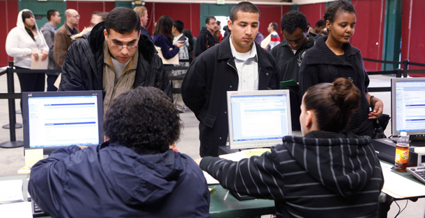 Job applicants, standing, talk with job recruiters at a job fair in Santa Clara, California earlier this year. (AP/Paul Sakuma)