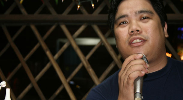 A man sings karaoke in a Filipino bar. <i>The New York Times</i> recently reported that people in the Philippines are killing each other over karaoke versions of Frank Sinatra's "My Way," but the article's sources are questionable and very little information is verified, drawing attention to the ability of journalists to make vague claims. (Flickr/<a href=