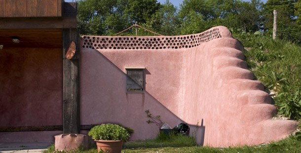 Old rubber car tires were packed with earth and used as building bricks covered in adobe plaster to build this wall. Recycling used tires into walls is a labor-intensive and time-consuming process, but it’s a sturdy alternative to more expensive construction where you actually have to pay for your materials. (Flickr/<a href=