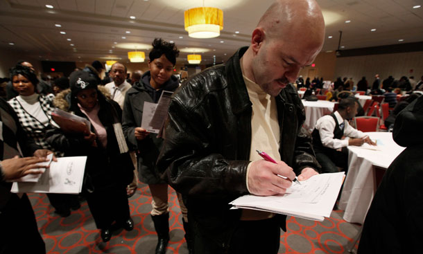 William Wright, of Detroit, fills out an application while standing in line at a job fair in Detroit on February 10, 2010. The unemployment insurance trigger provides extended weeks of UI benefits to those still without work after six months, but the system is not working as well as it could. (AP/Paul Sancya)