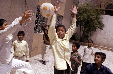 Homeless Yemeni children play in a courtyard. School is compulsory in Yemen, yet 20 percent to 30 percent of children do not attend. (AP/Bryant MacDougall)