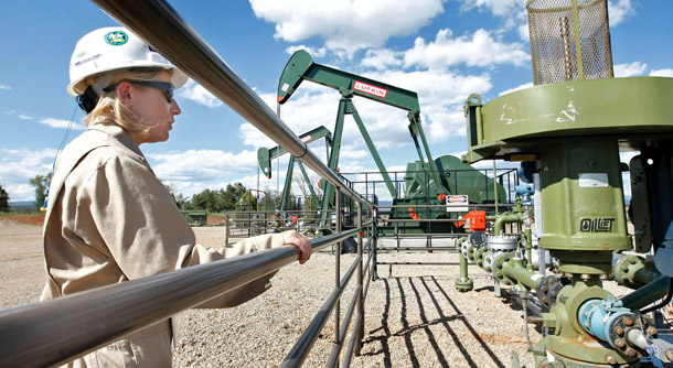A woman looks over a methane gas well site east of Bayfield, Colorado where three gas wells have been drilled and are producing natural gas. (AP/Jerry McBride)